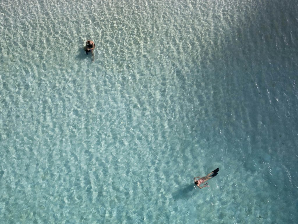 Vista aérea de dos personas nadando en las aguas turquesas de Balandra, La Paz